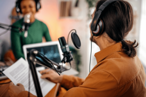 Young man and woman recording podcast.